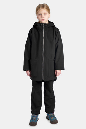 Child wearing a black coat and pants on a white background