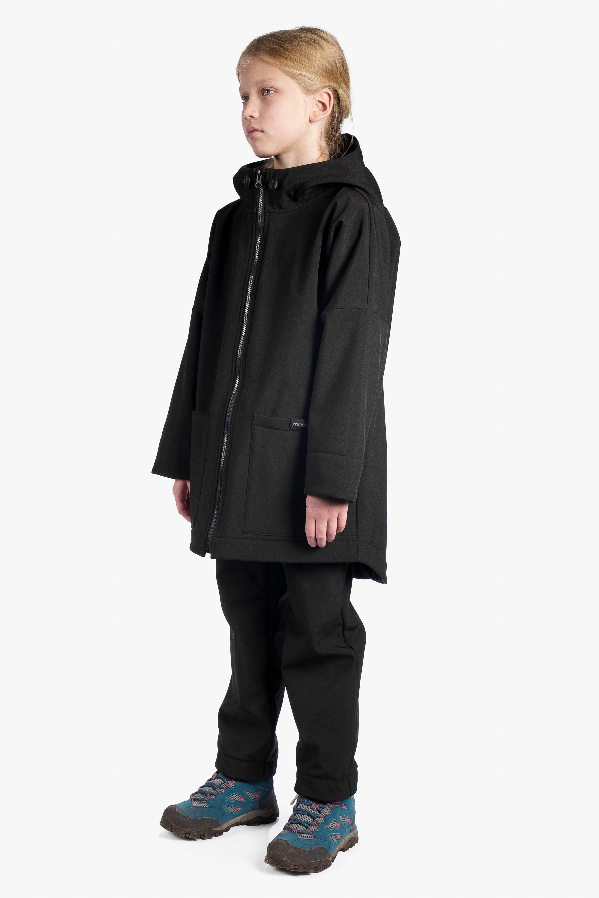 Child wearing a black coat and pants on a white background