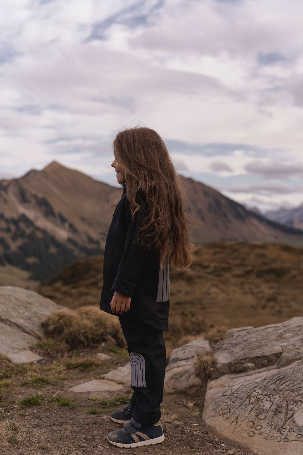Schwarze Softshell-Regenjacke für Kinder mit reflektierendem Regenbogenmuster