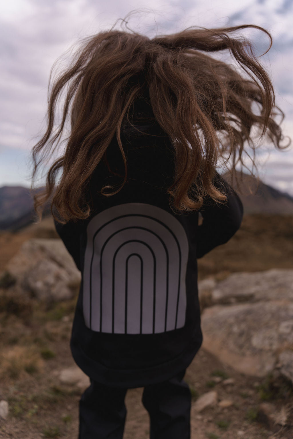 Schwarze Softshell-Regenjacke für Kinder mit reflektierendem Regenbogenmuster