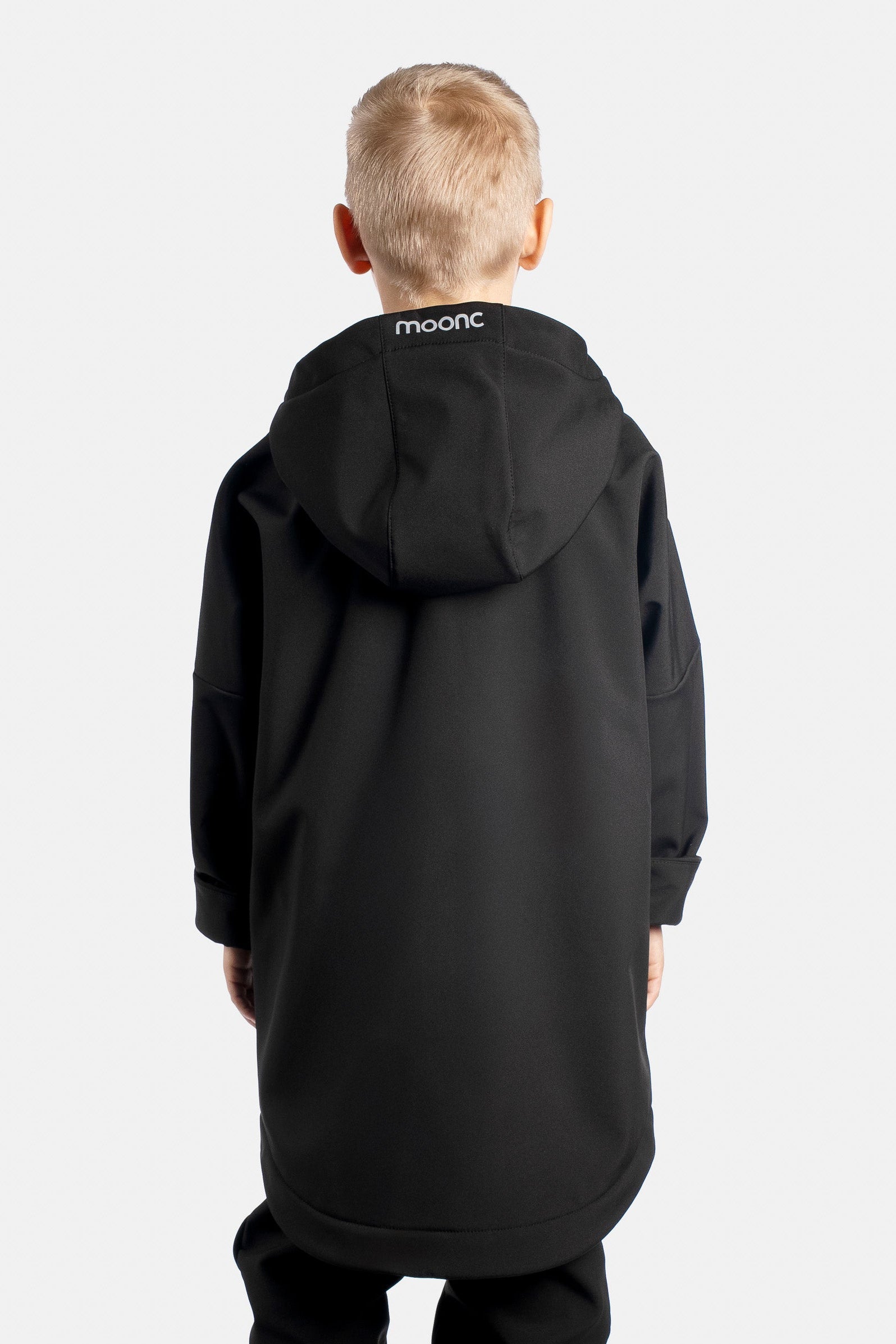 Child wearing a black softshell jacket with 'moonc' branding on the hood back against a white background