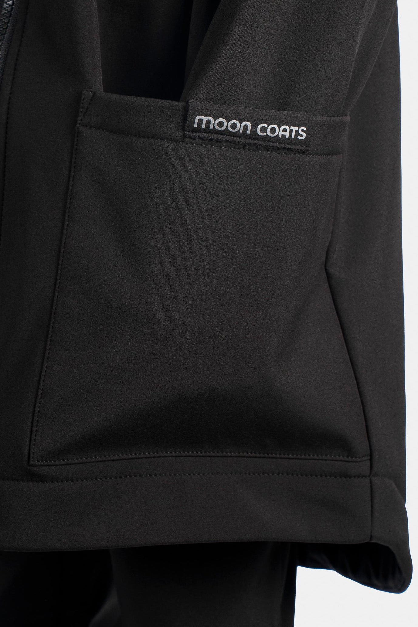 Black jacket with 'moon coats' logo on a white background