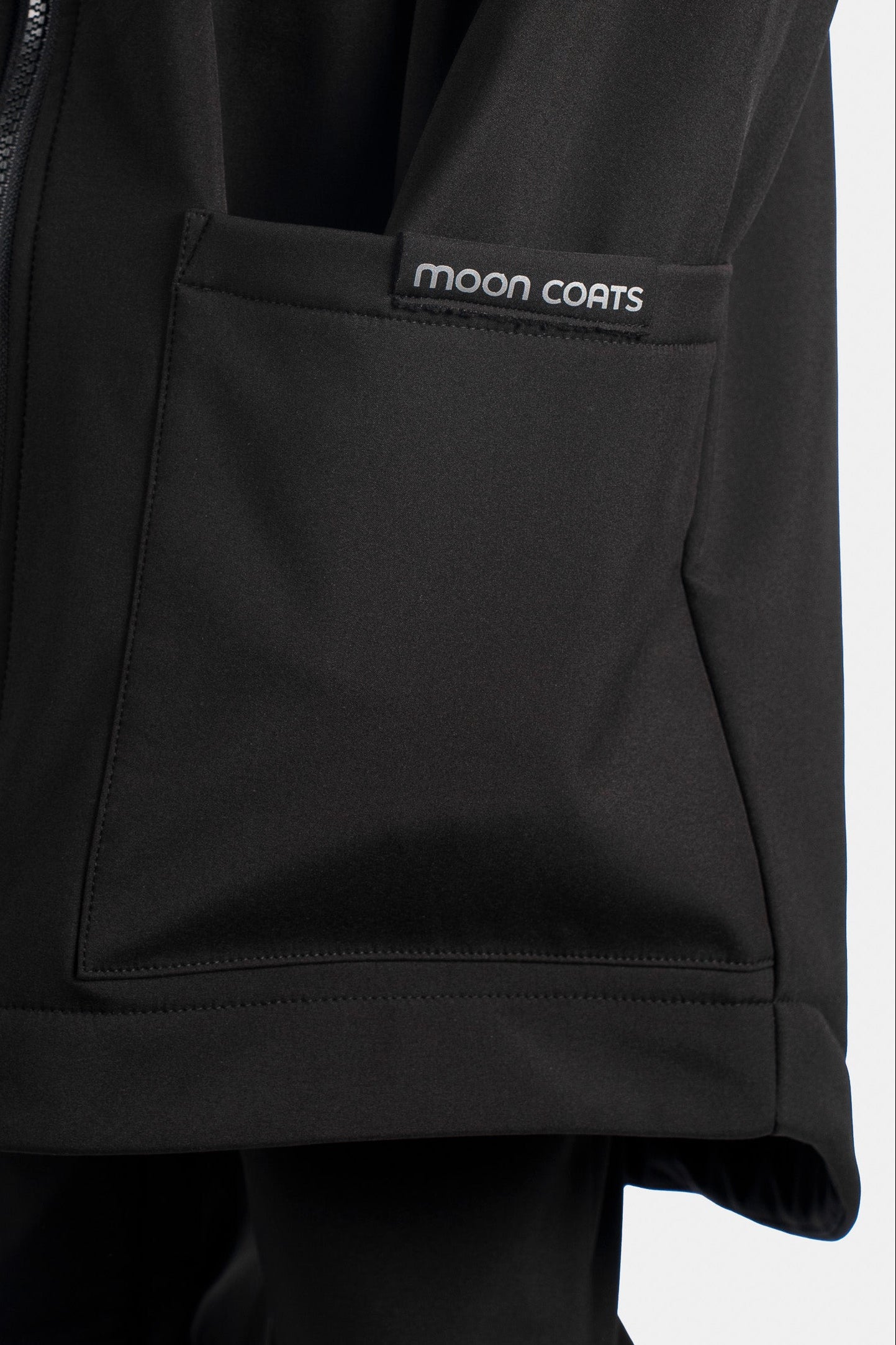 Black jacket with 'moon coats' logo on a white background