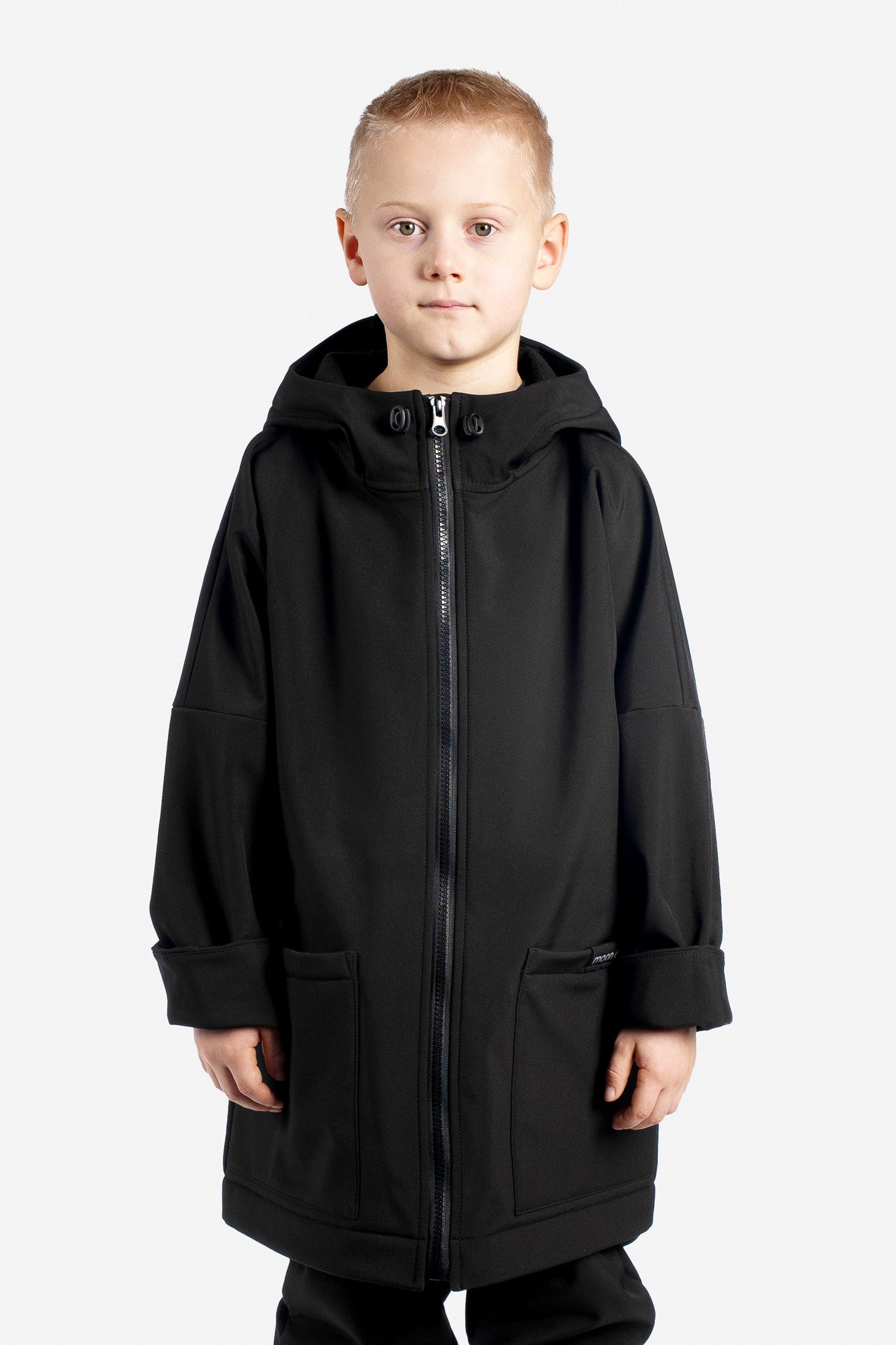 Child wearing a black coat on a white background