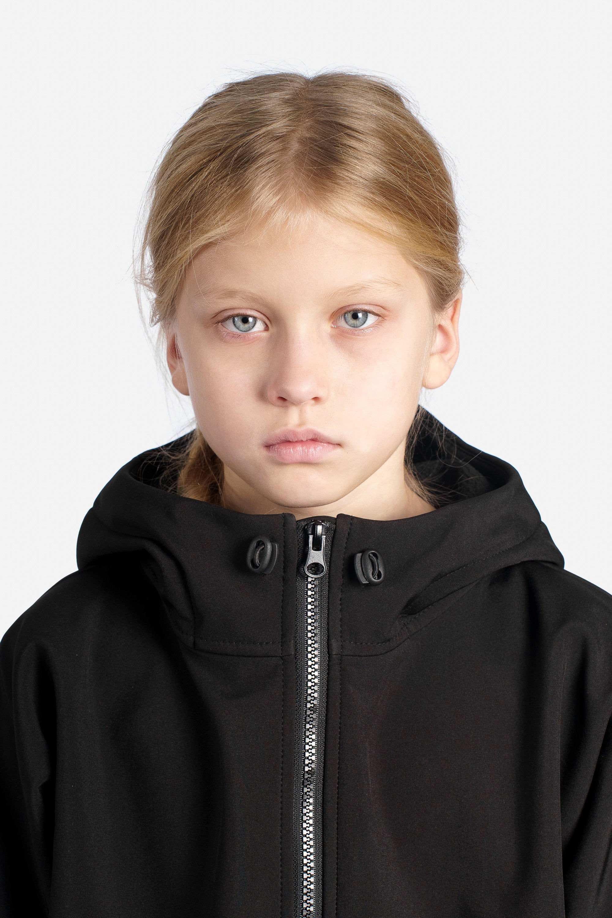 Girl wearing a black jacket with a zipper on a white background