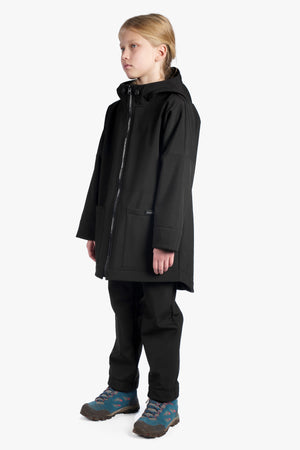 Child wearing a black coat and pants on a white background