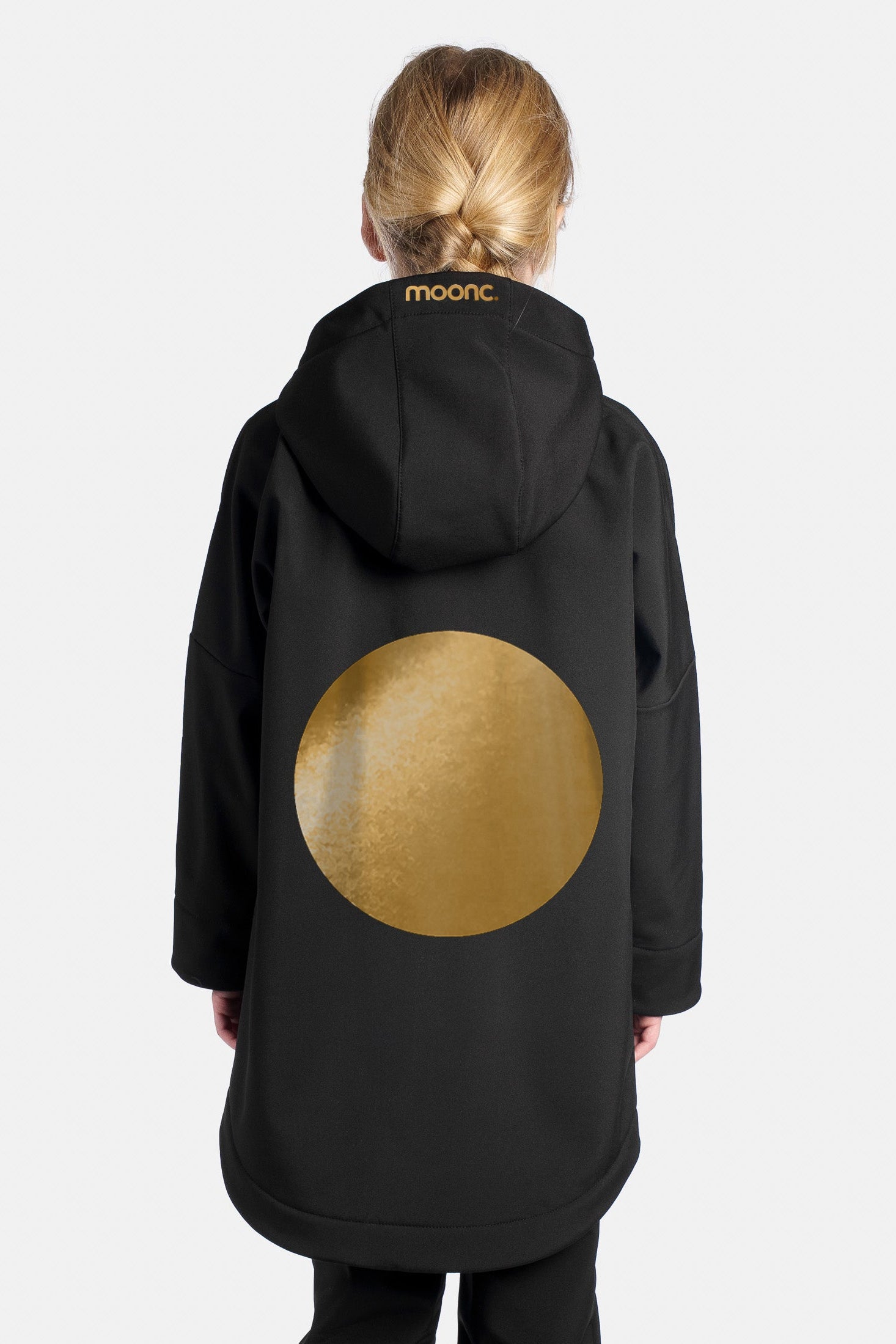 Child wearing a black coat with a gold circle design on the back.