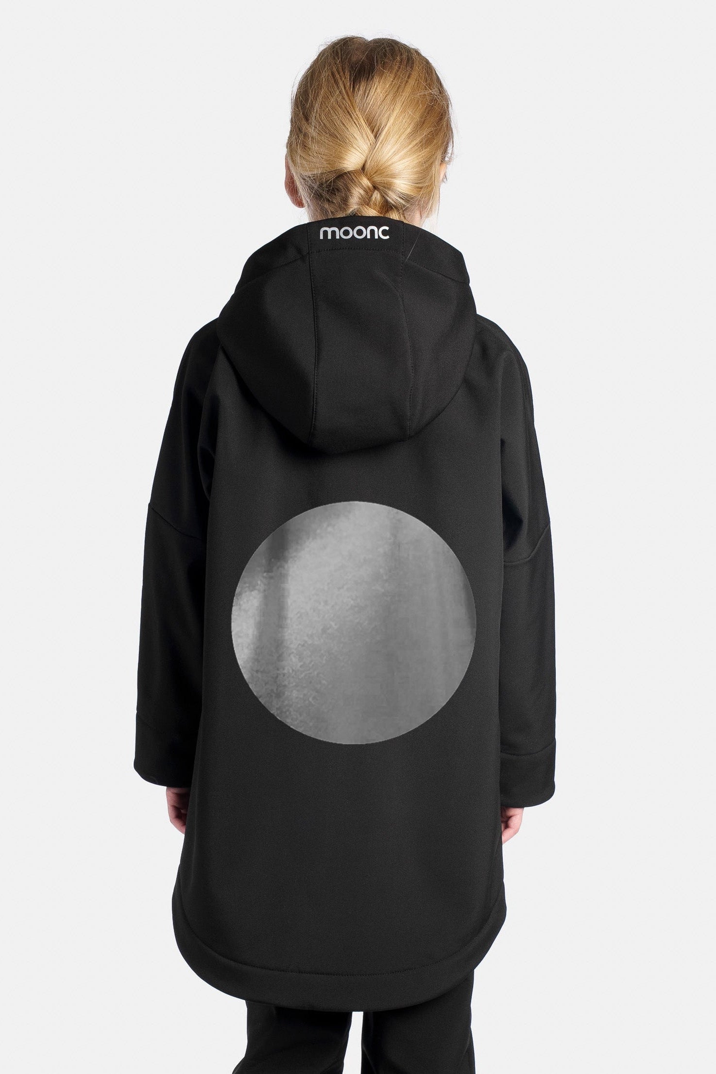Person wearing a black coat with a moon design on the back, standing against a white background.