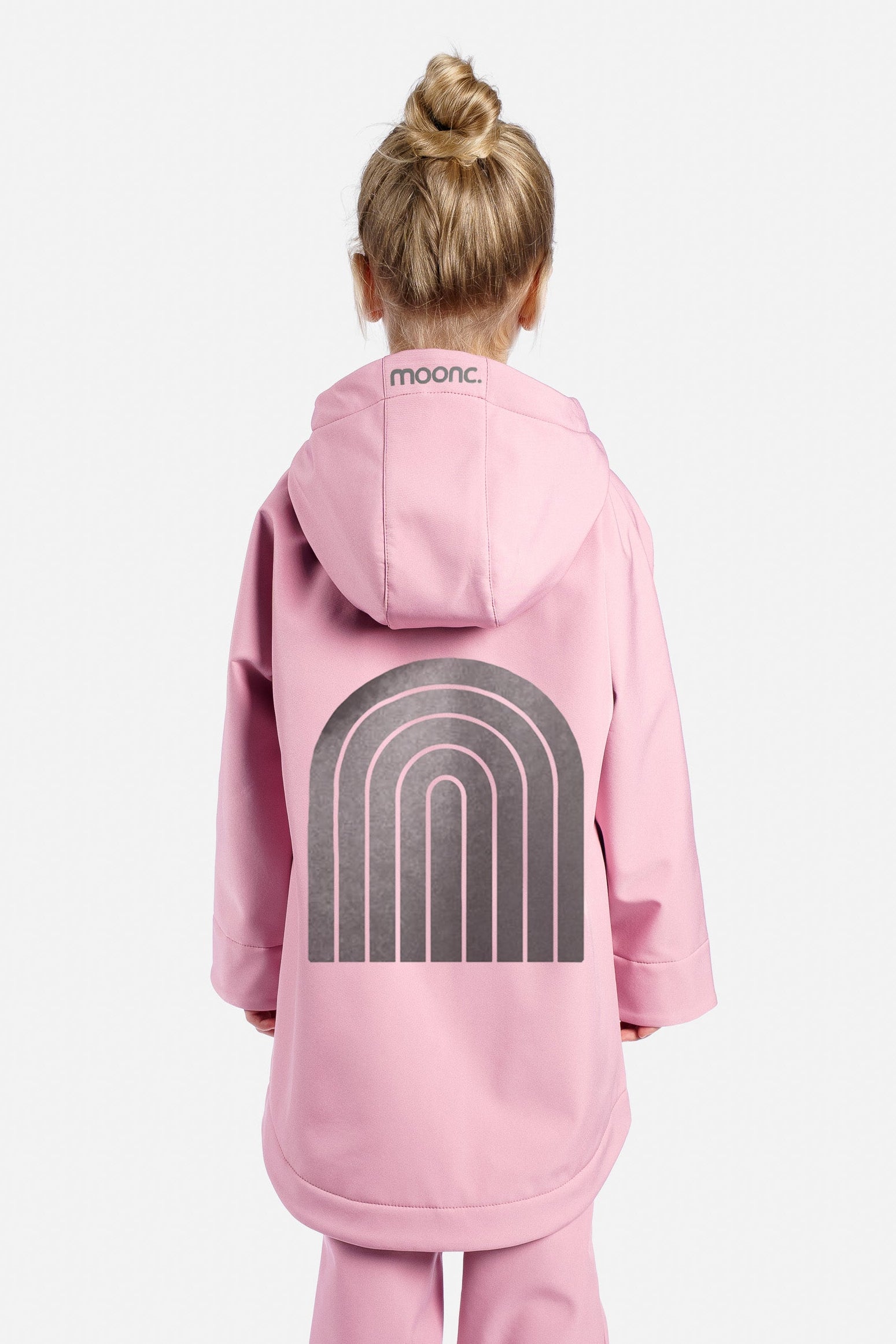 Child wearing a pink onesie with a rainbow design on a white background