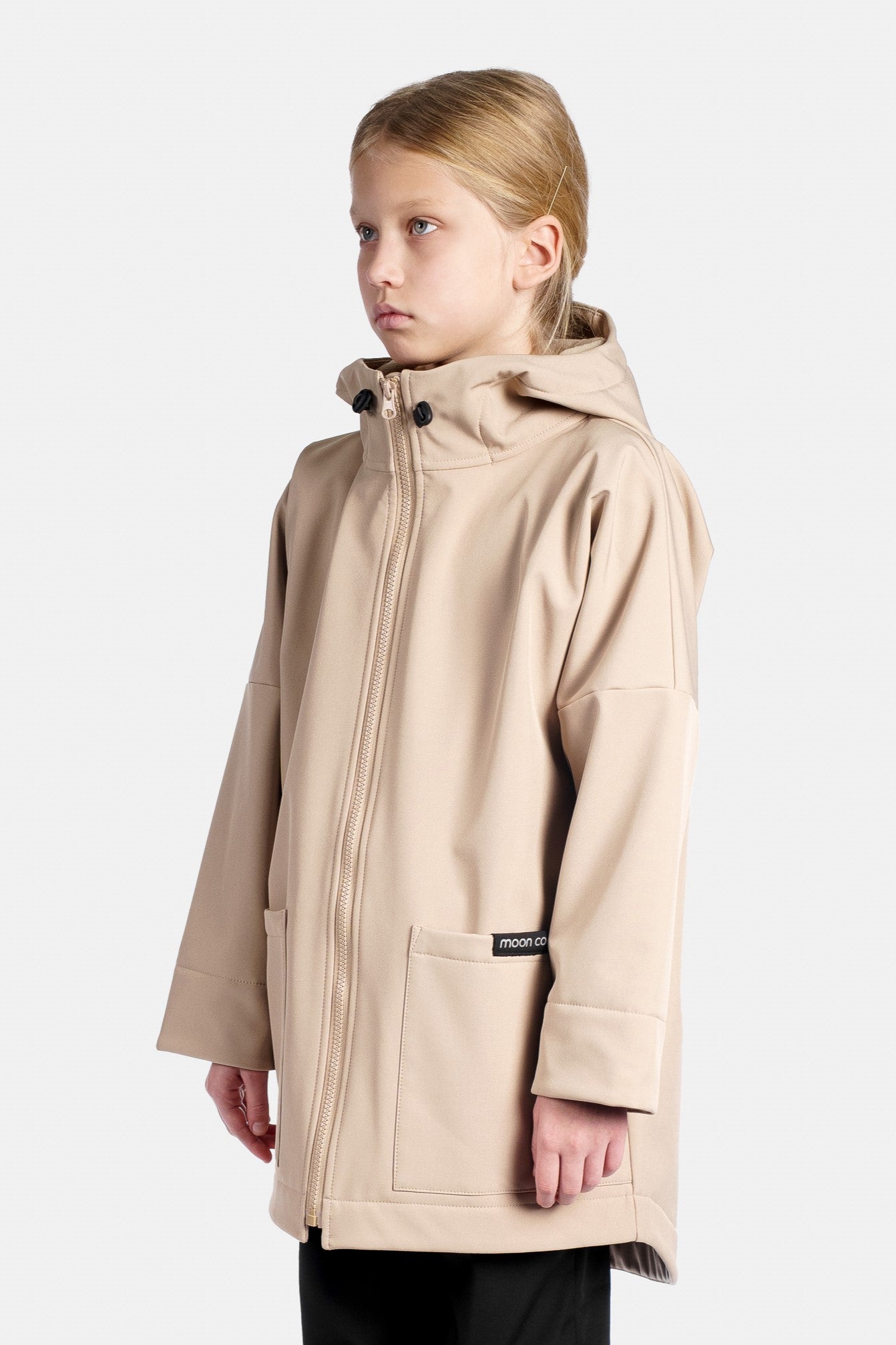 Child wearing a beige rain jacket with a hood on a white background